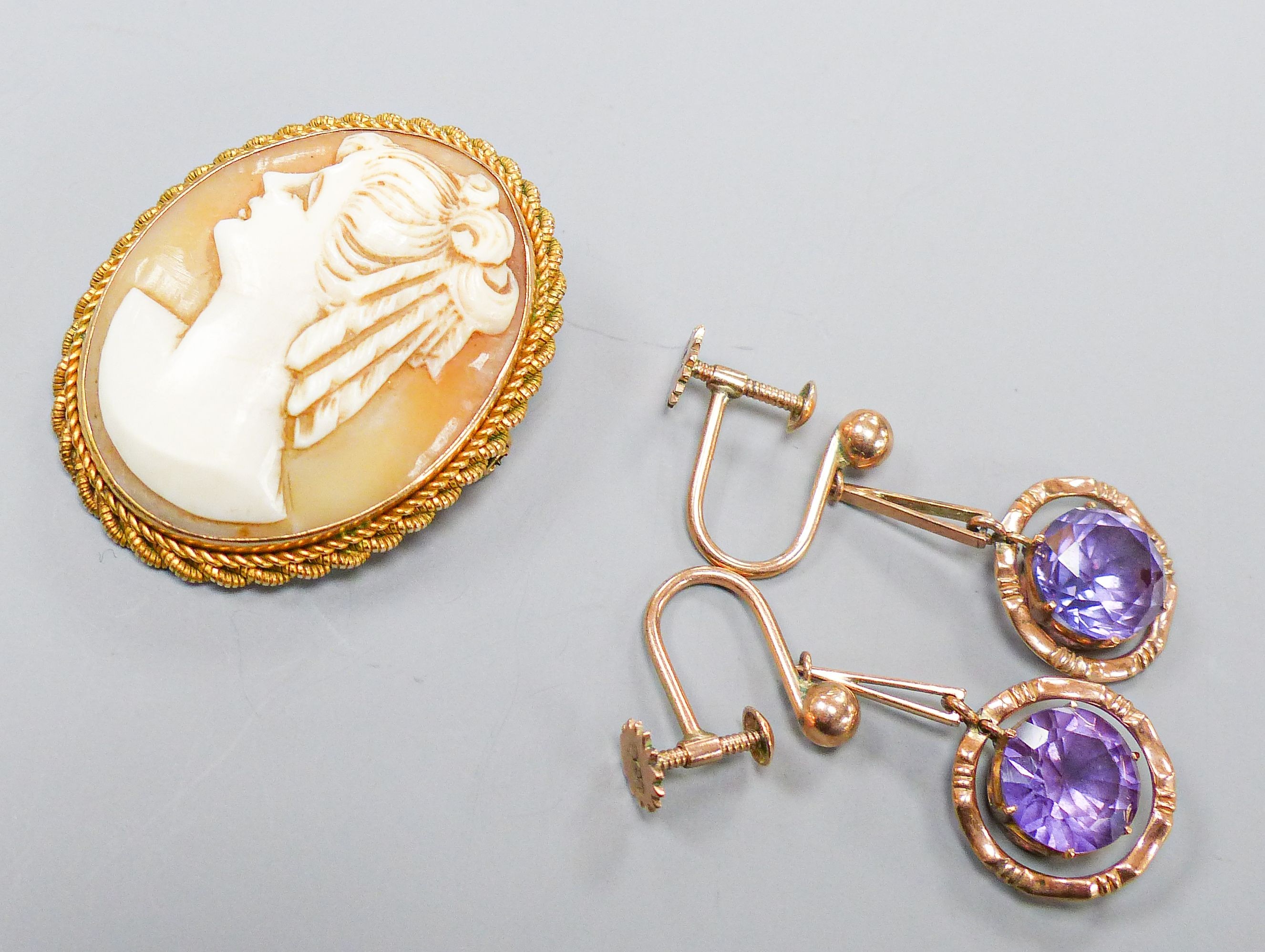 An oval cameo brooch in 9ct mount with rope-twist edge, 35mm and a pair of 9ct drop earrings set with circular synthetic sapphires, gross weight 12.8 grams.